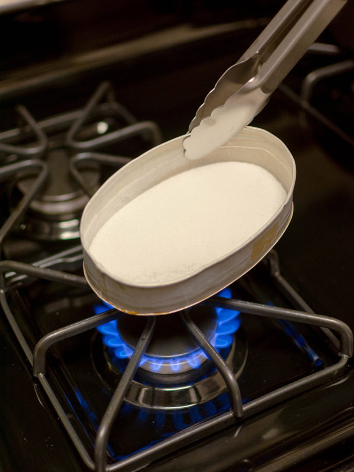 Sugar in a llanera over a stove top.