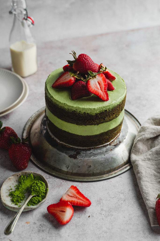 45 degree angle of a whole vegan matcha strawberry cake