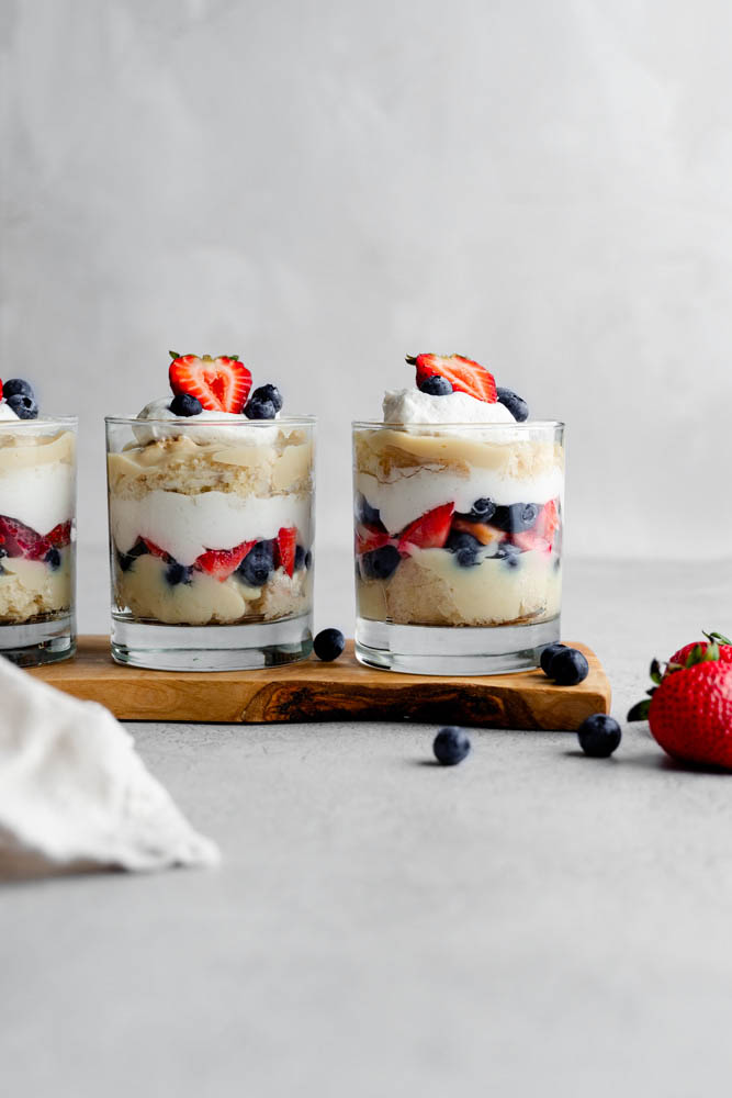 3 cups of vegan berry trifle cups in line. Showing the layers of the trifles. 