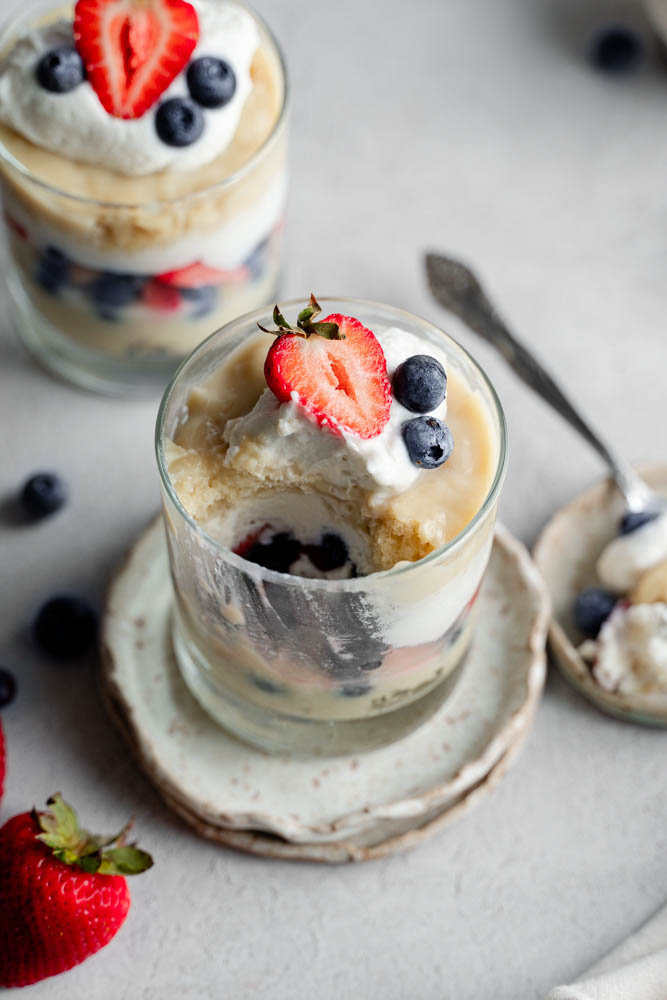 A single of a vegan berry trifle cup a portion of it was taken out of it.