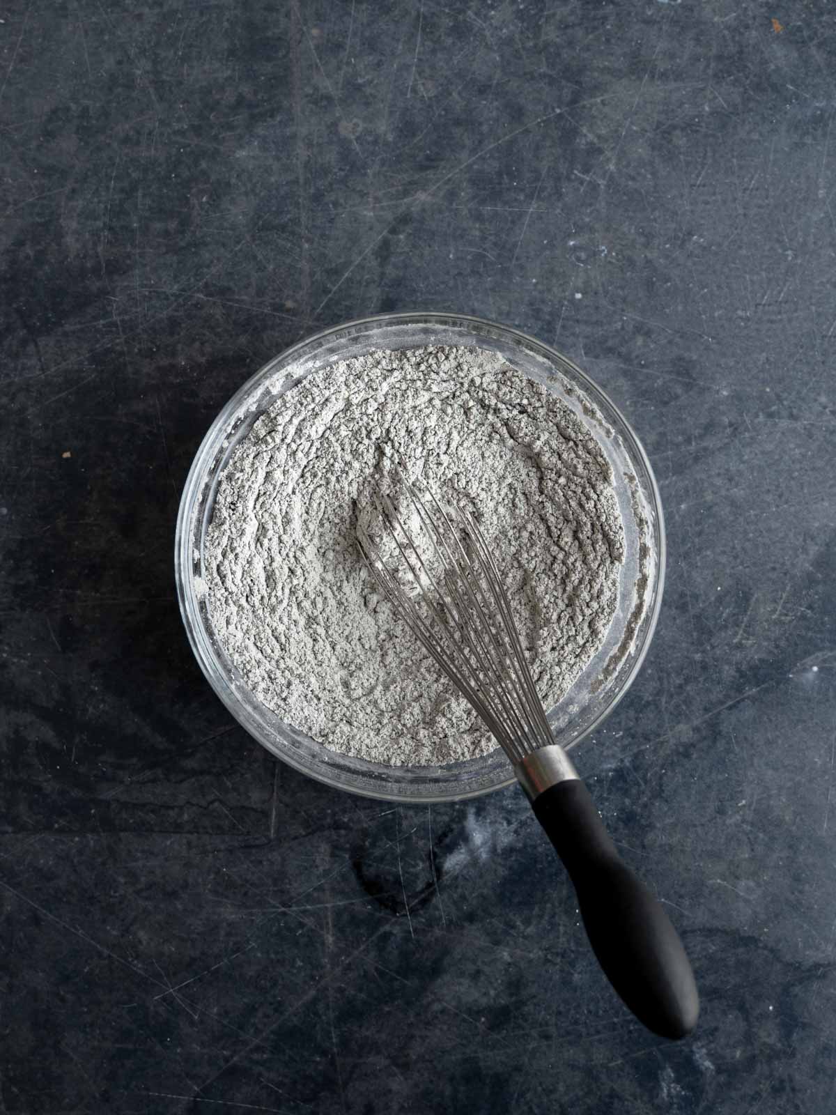 Dry ingredients whisked in a glass bowl.