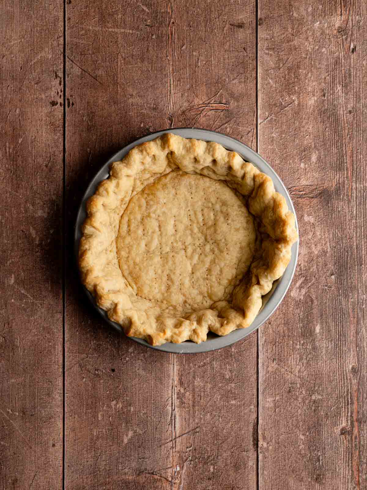A golden brown blind baked pie crust with the parchment and pie weights removed.