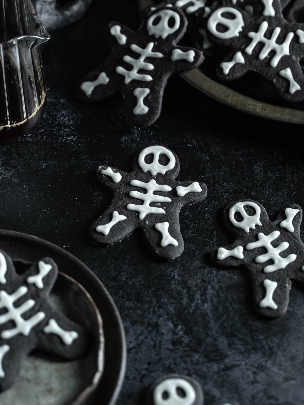 A skeleton cookie on a surface surrounded by other skeleton cookies.