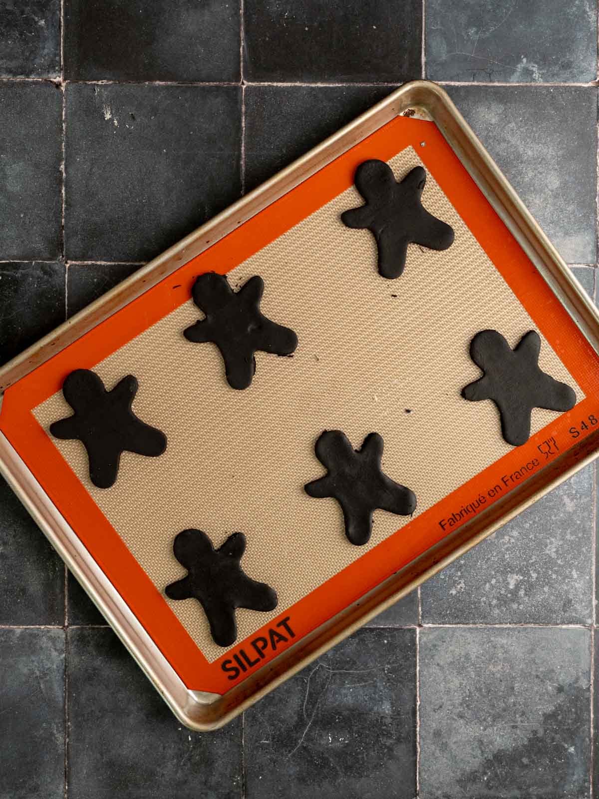 Cut out cookies placed on a baking sheet.
