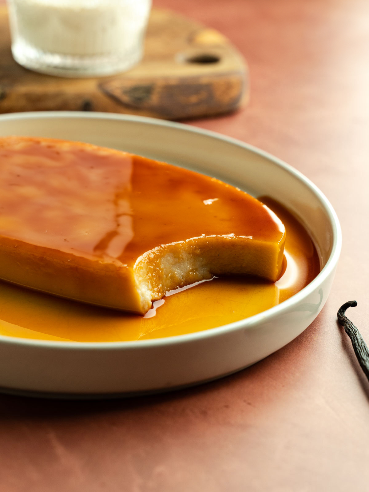 Vegan leche flan on a plate with a spoonful taken out of it.