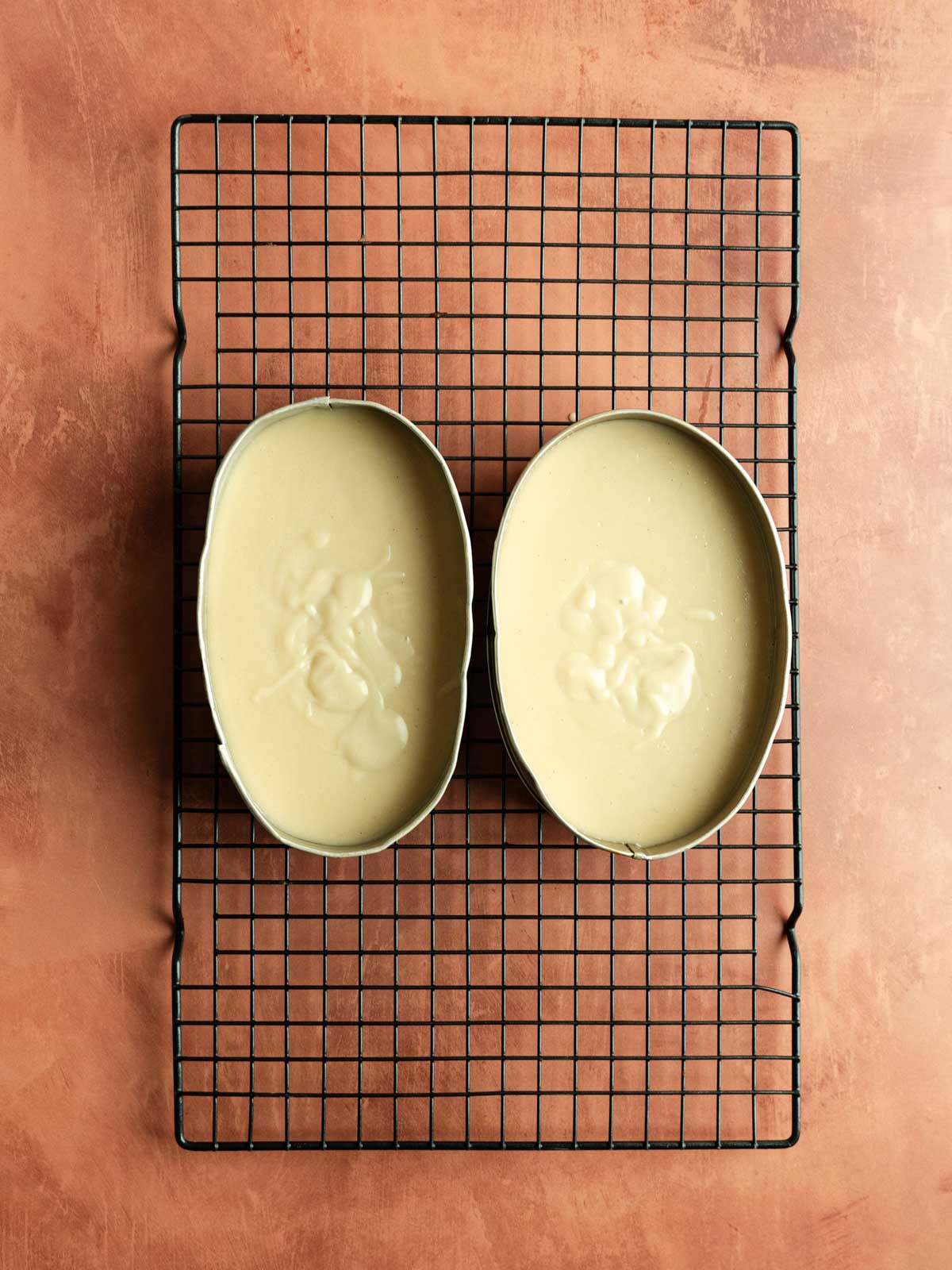 Cooked vegan leche flan mixture poured over the cooled caramel, into the llanera.