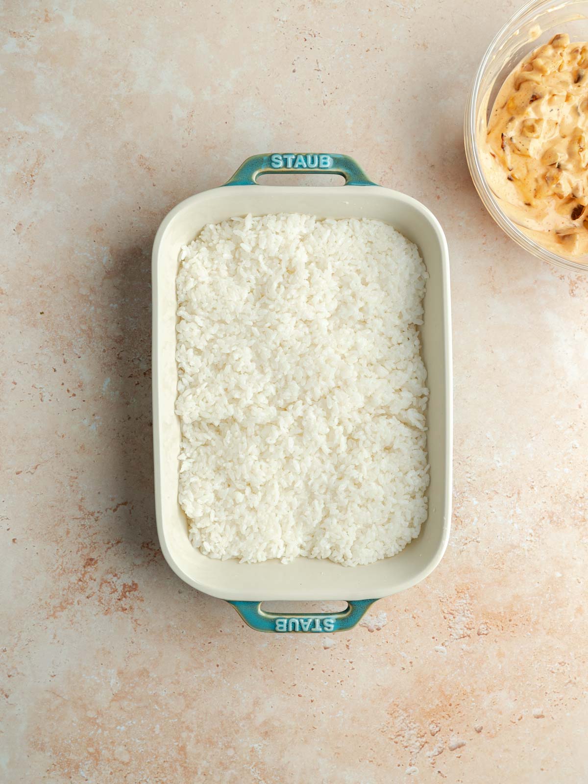 Sushi rice in a pressed into the bottom of a casserole dish.