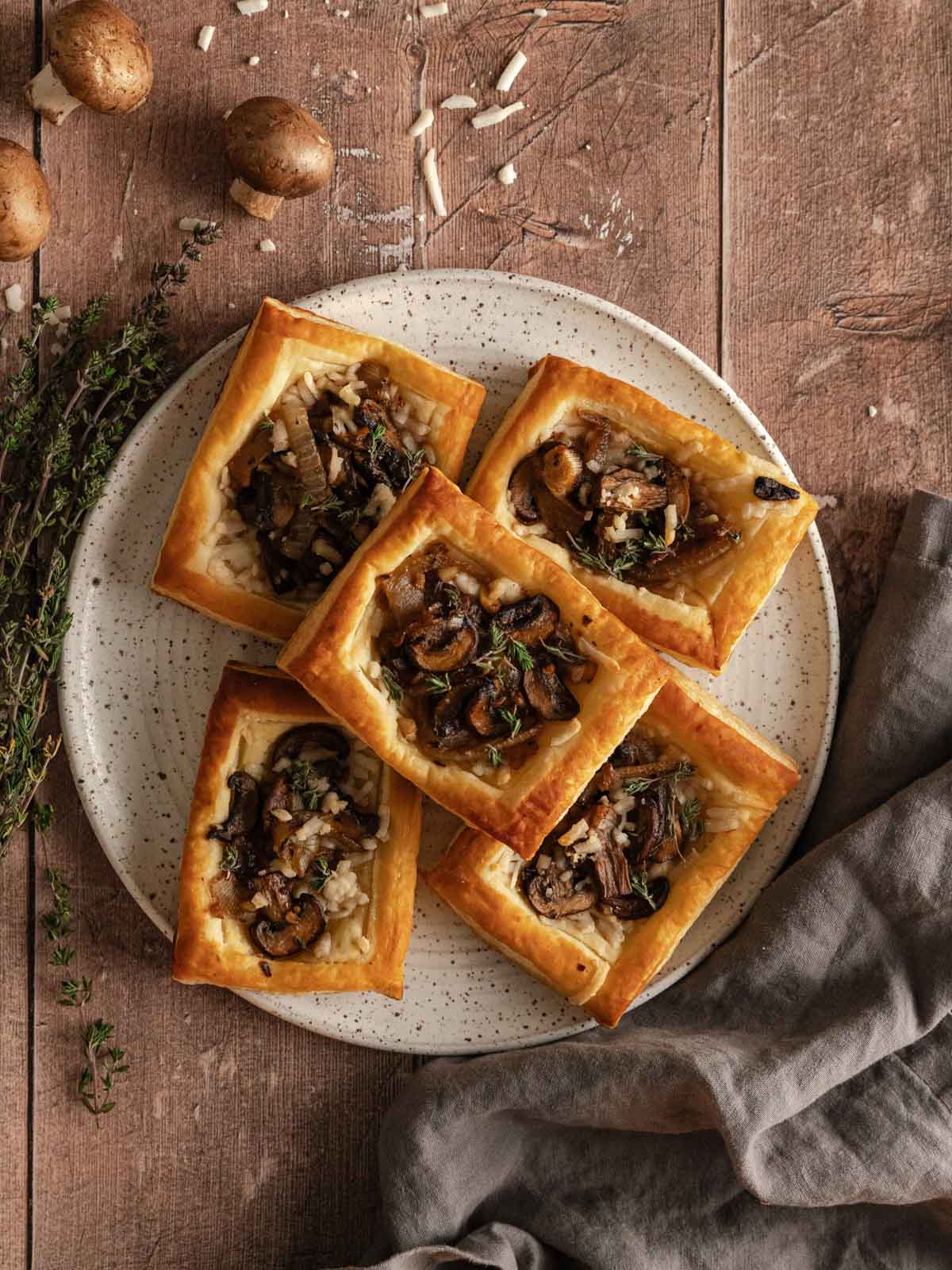 Mushroom tarts on a plate layered on top of each other.