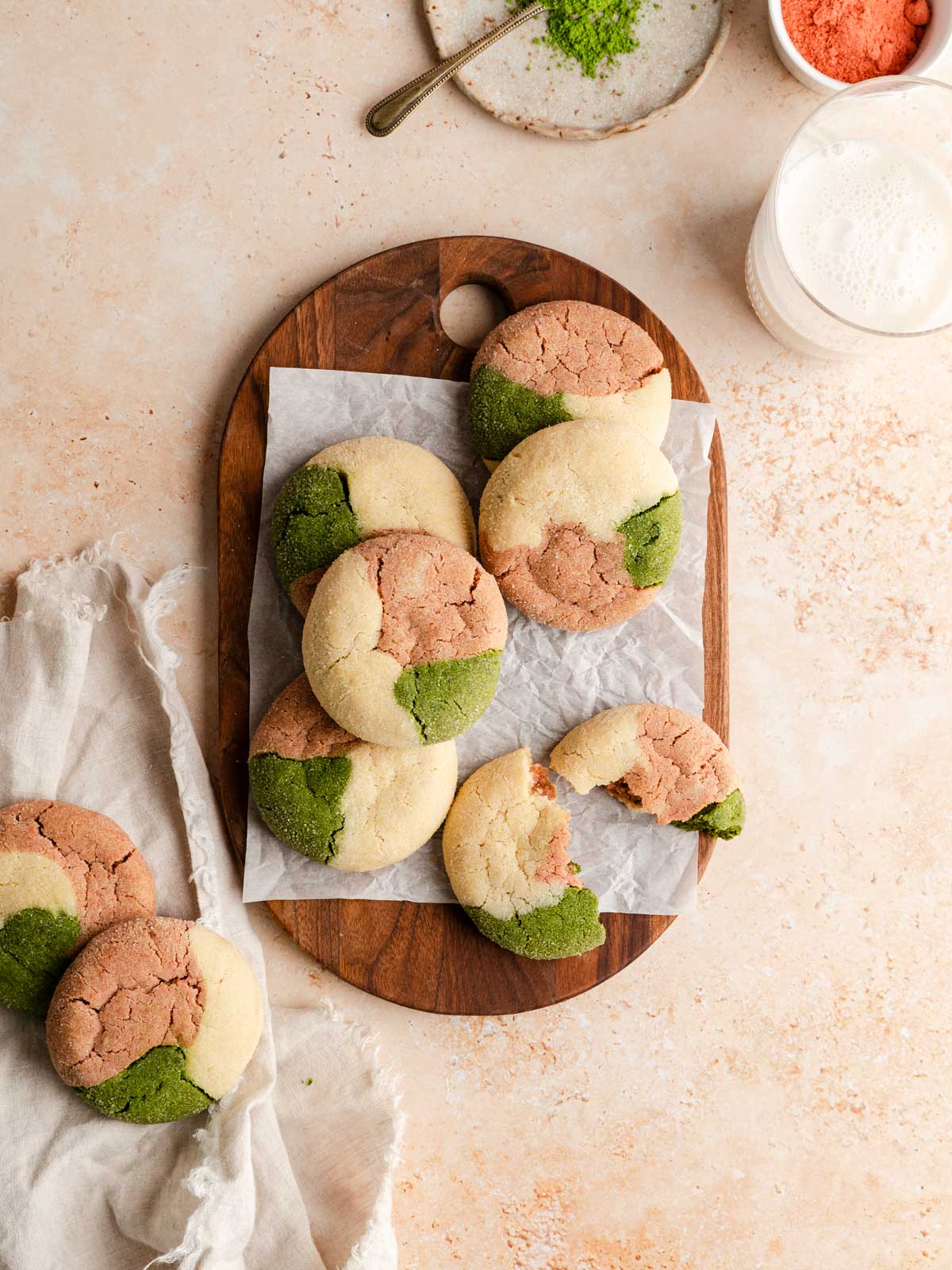 A pile of vegan matcha neapolitan cookies over a wooden board.