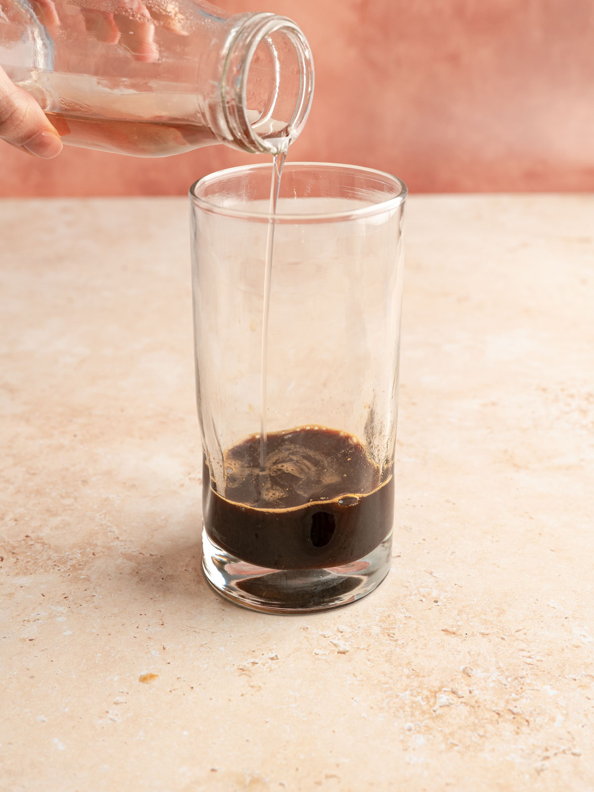 Syrup poured into a glass with espresso.