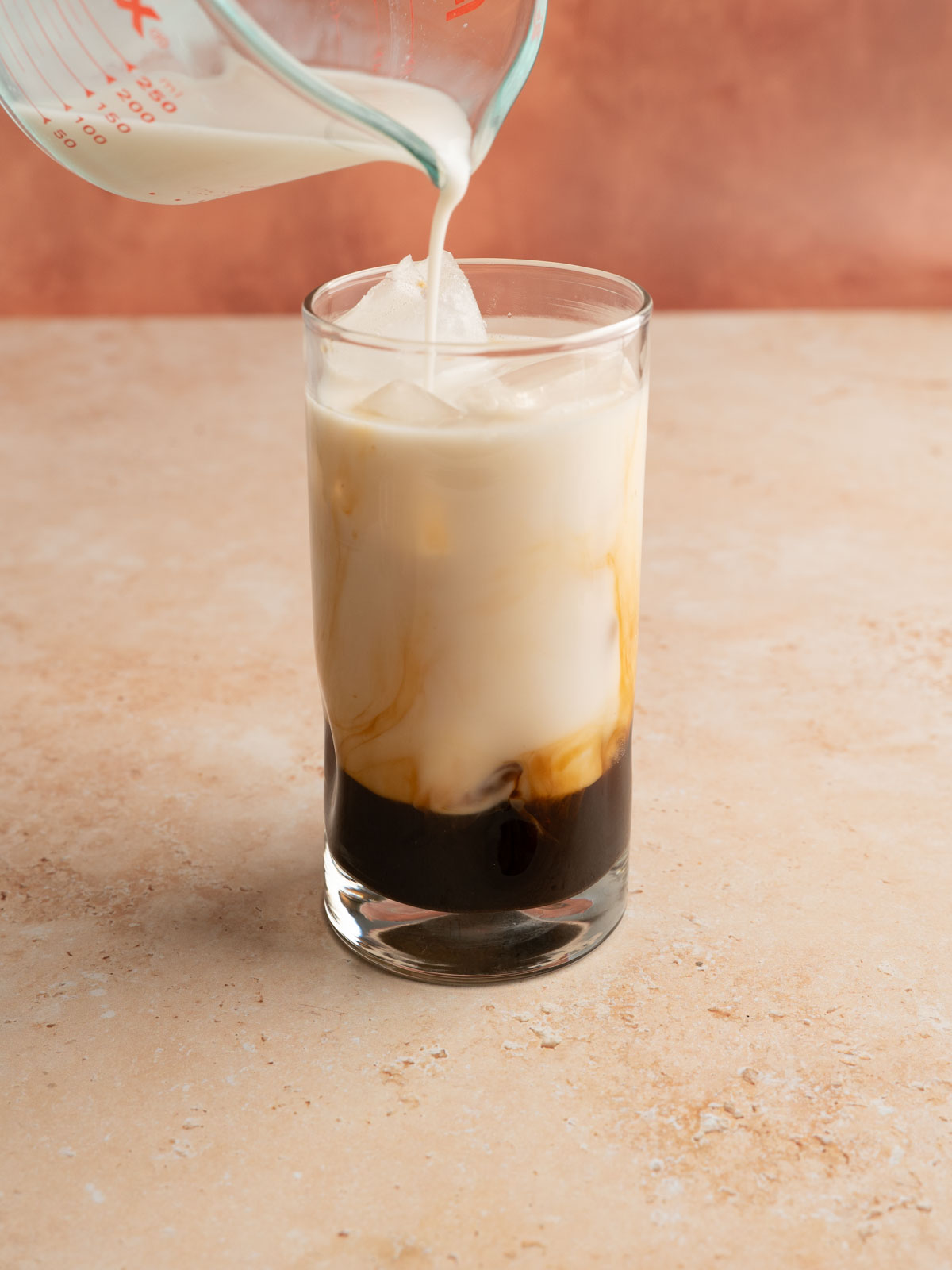 Milk added over ice and the rose cardamom infused espresso.