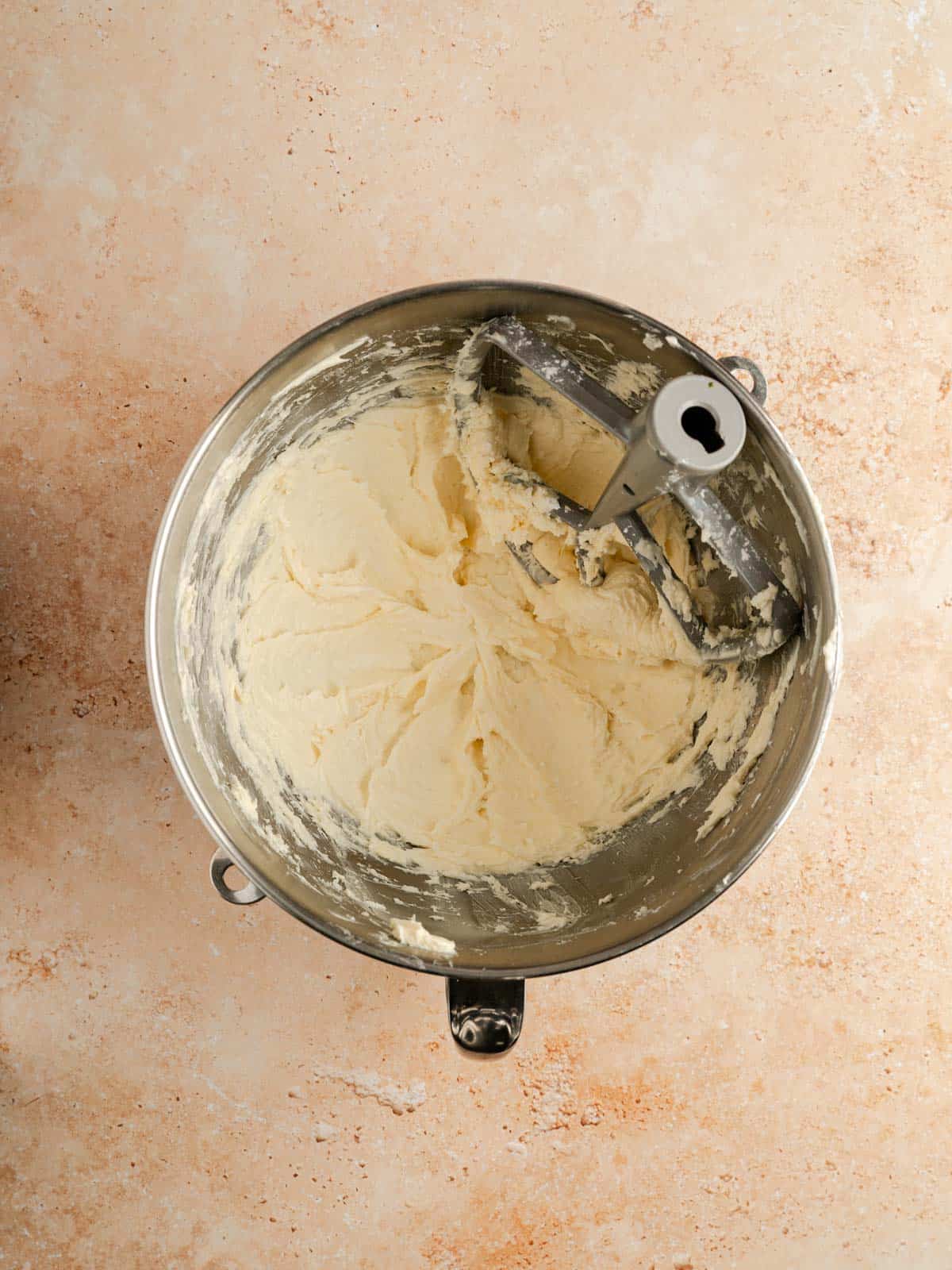 Butter and powdered sugar creamed in a stand mixer bowl with a paddle attachment.