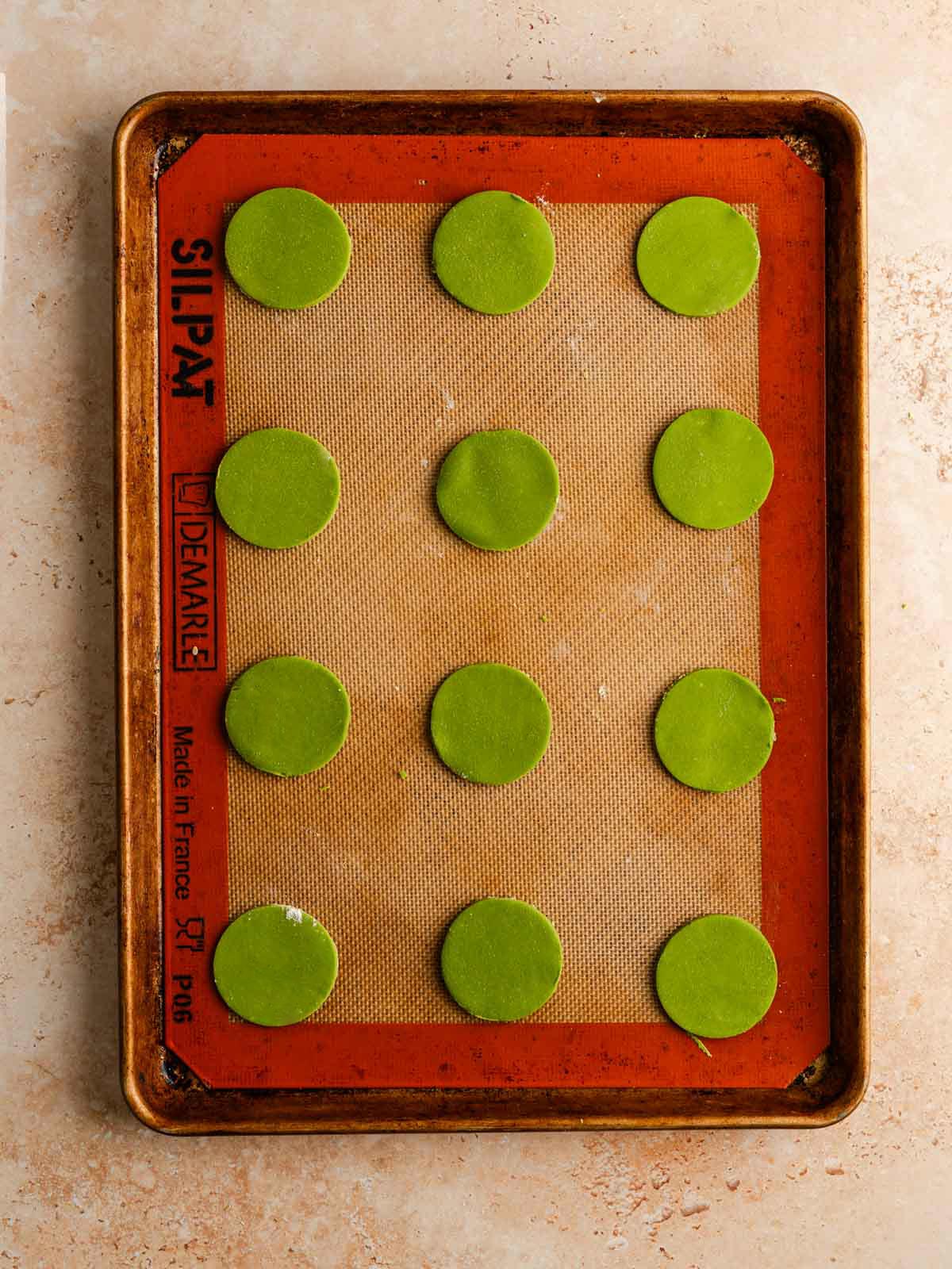 Unbaked matcha cookies on a baking sheet.