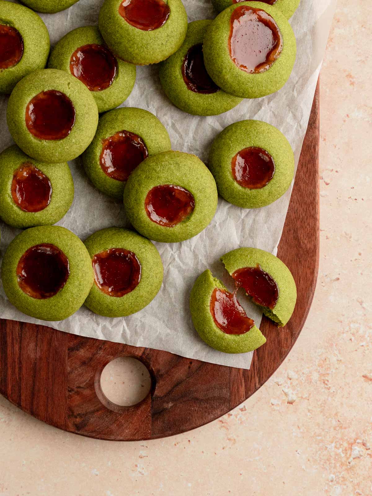 A board matcha cookies with one broken in half.