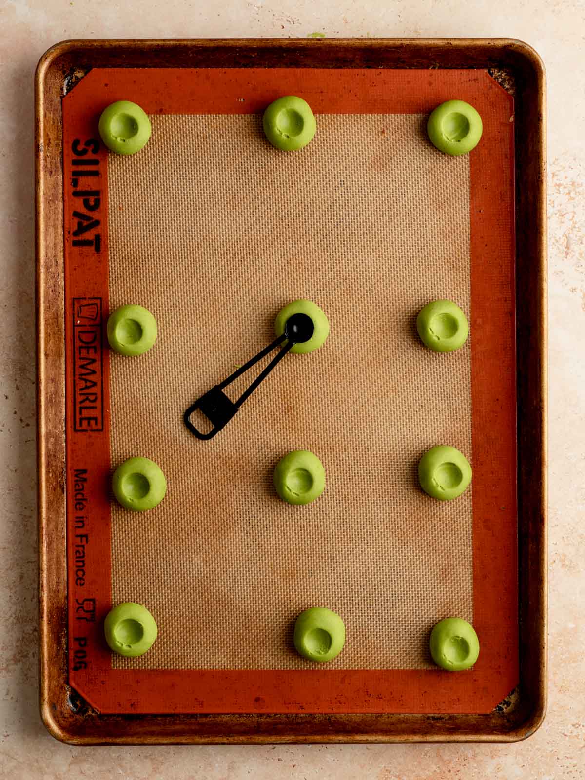 Matcha cookie dough indented with a quarter teaspoon.