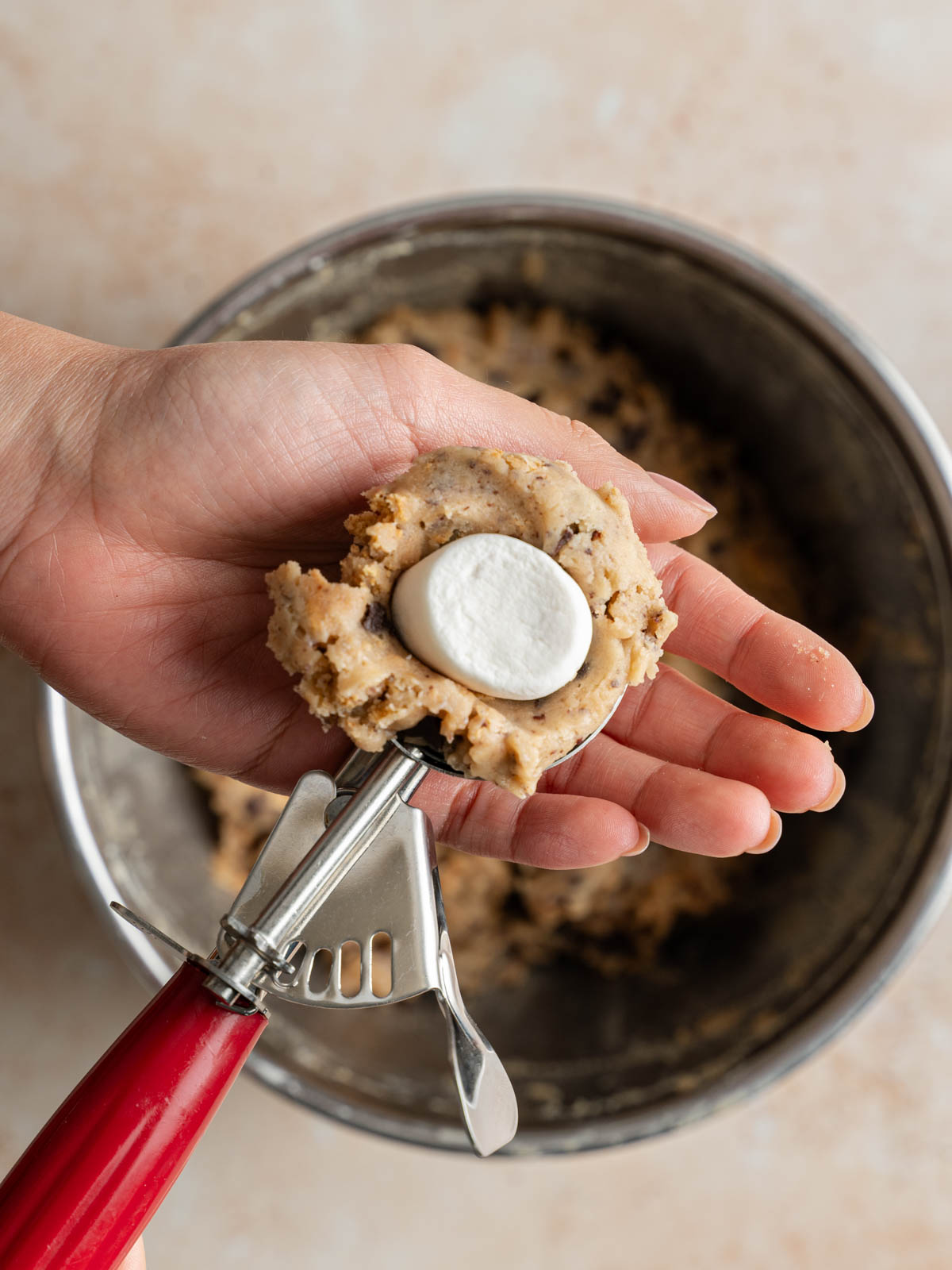 Scoop the cookie dough and add one half of the marshmallows in the middle.