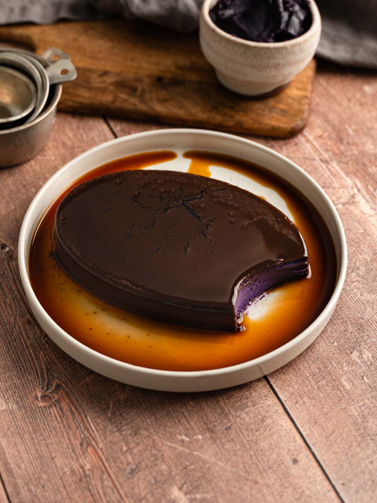 A plate of vegan ube leche flan with a bite taken from it.