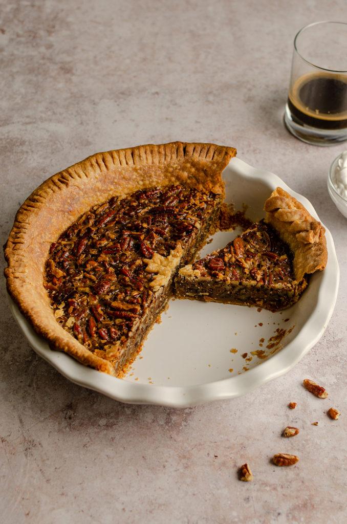 45 degree angle of half of a vegan maple bourbon pecan pie.