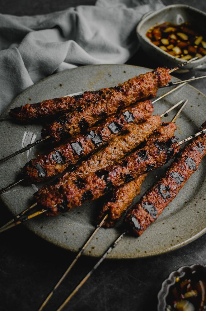 45 degree angle of barbecue skewers on a plate.