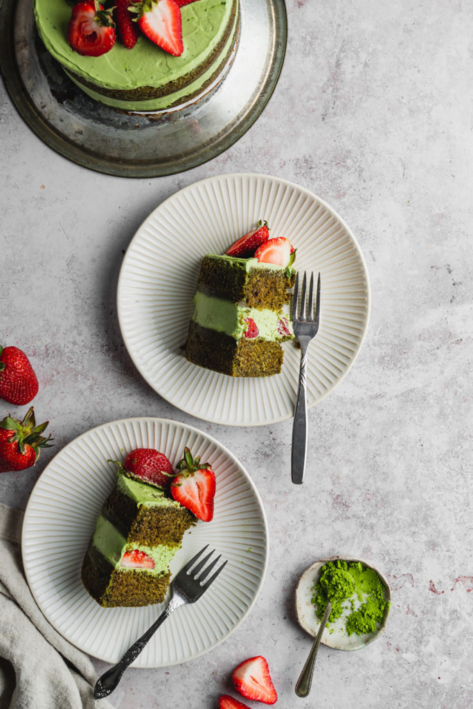 Top view of two slices of vegan matcha strawberry cake  served on two individual plates