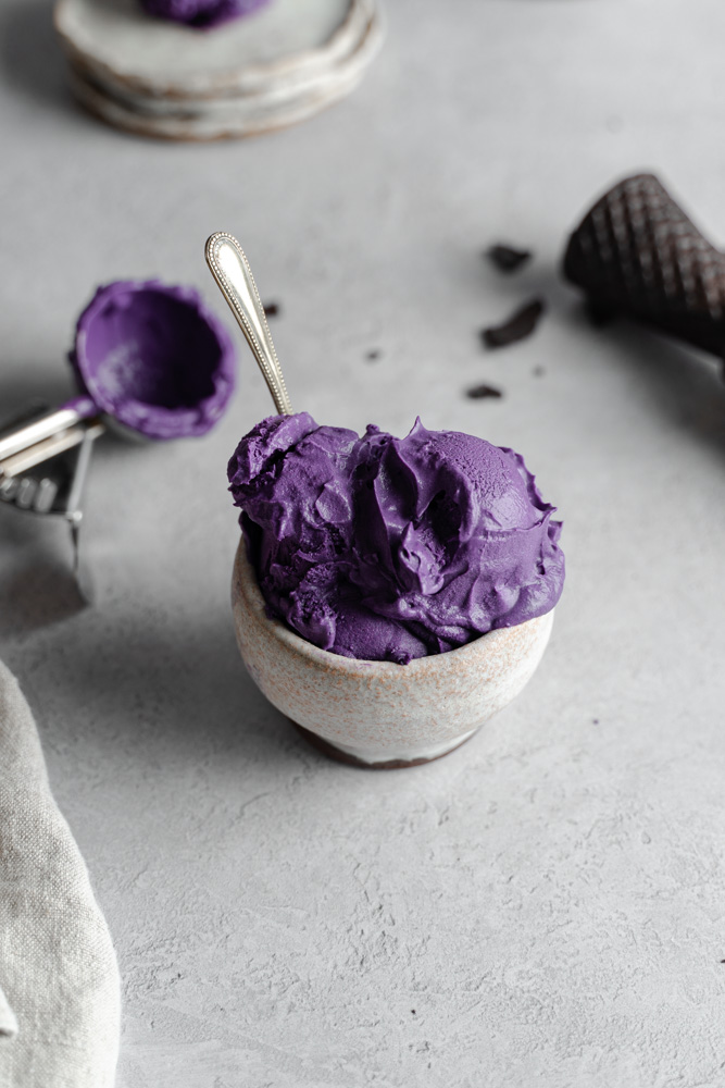 ube ice cream in a bowl with a spoon inside.