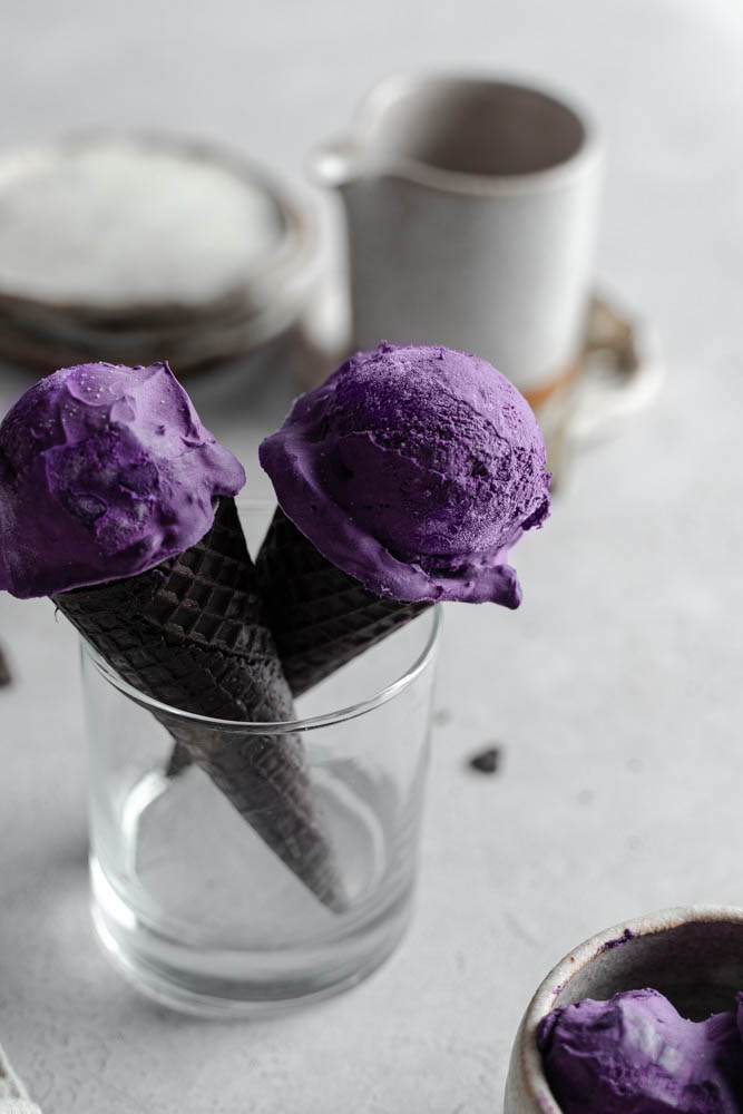 ube ice cream in an oreo cone, standing in a glasss cup