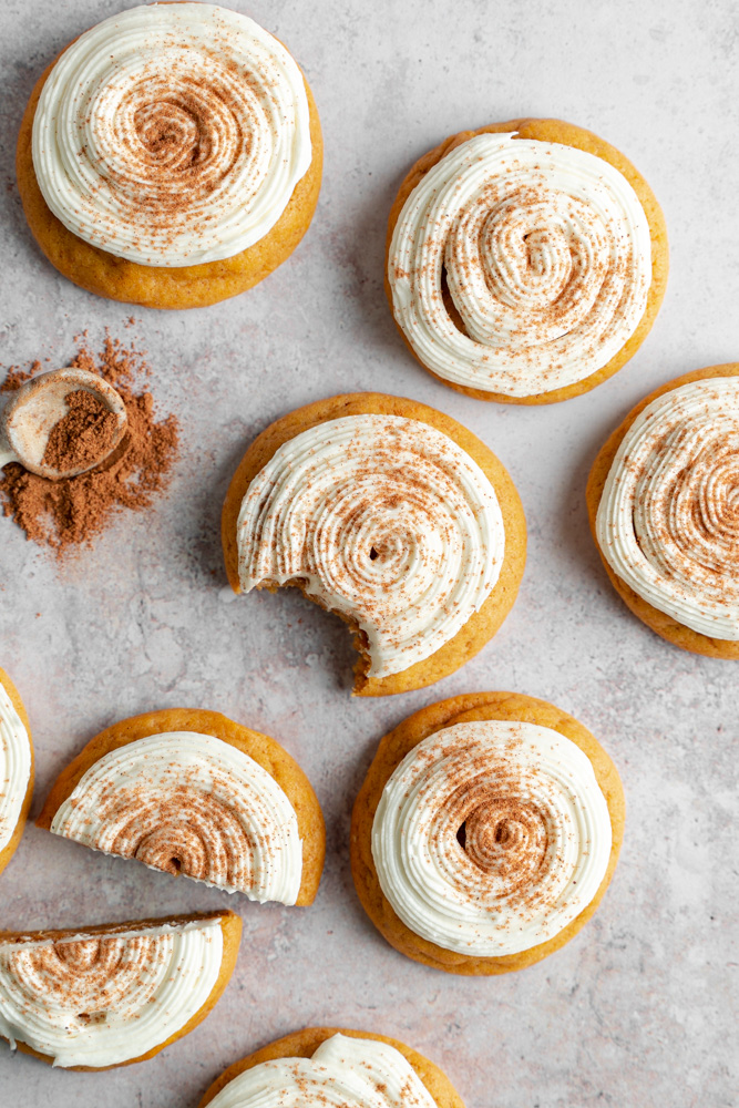 Pumpkin cookies spread out on a surface.