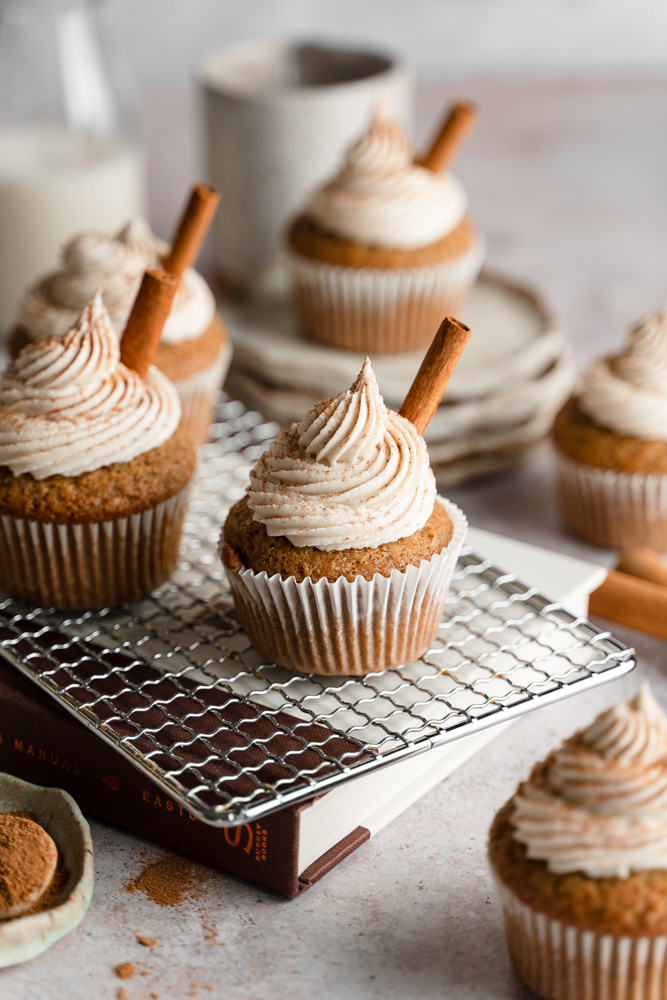 Vegan chai latte cupcakes sitting on top of books.