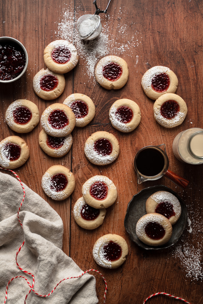a bunch of thumbprint cookies laid ontop of a wooden table