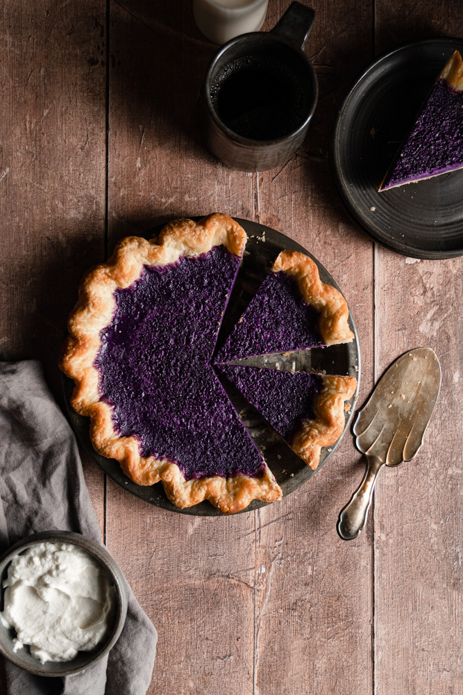 Vegan ube pie with 3 slices cut into it inside the pie plate