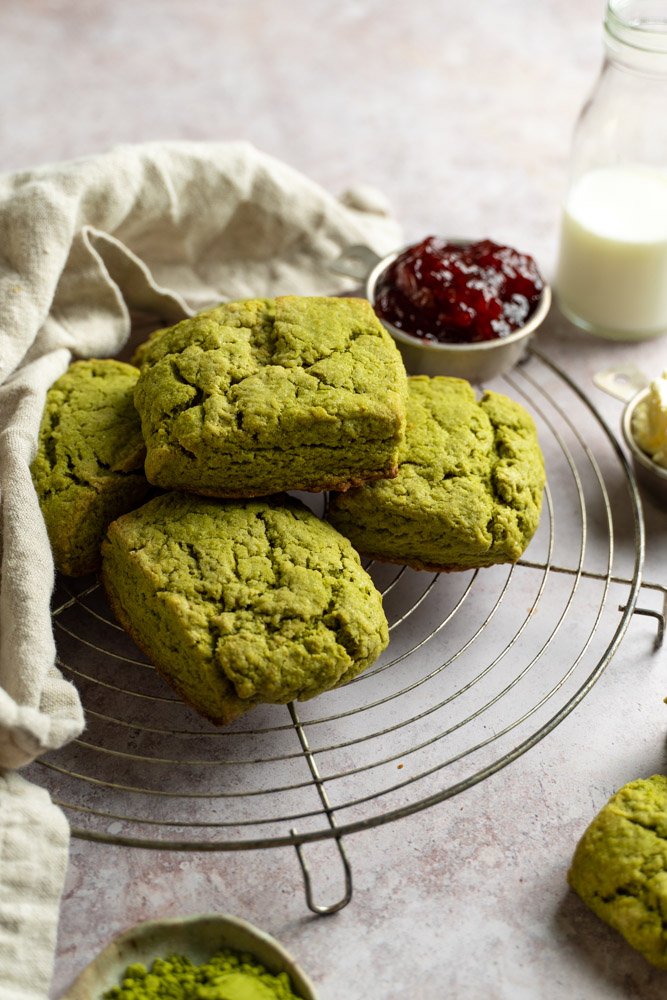 Stacked matcha scones on top of a round cooling rack.