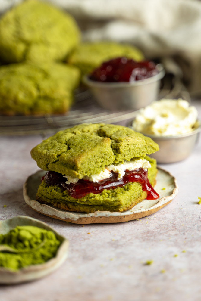 A sandwiched vegan matcha scone filled with jelly and vegan clotted cream.
