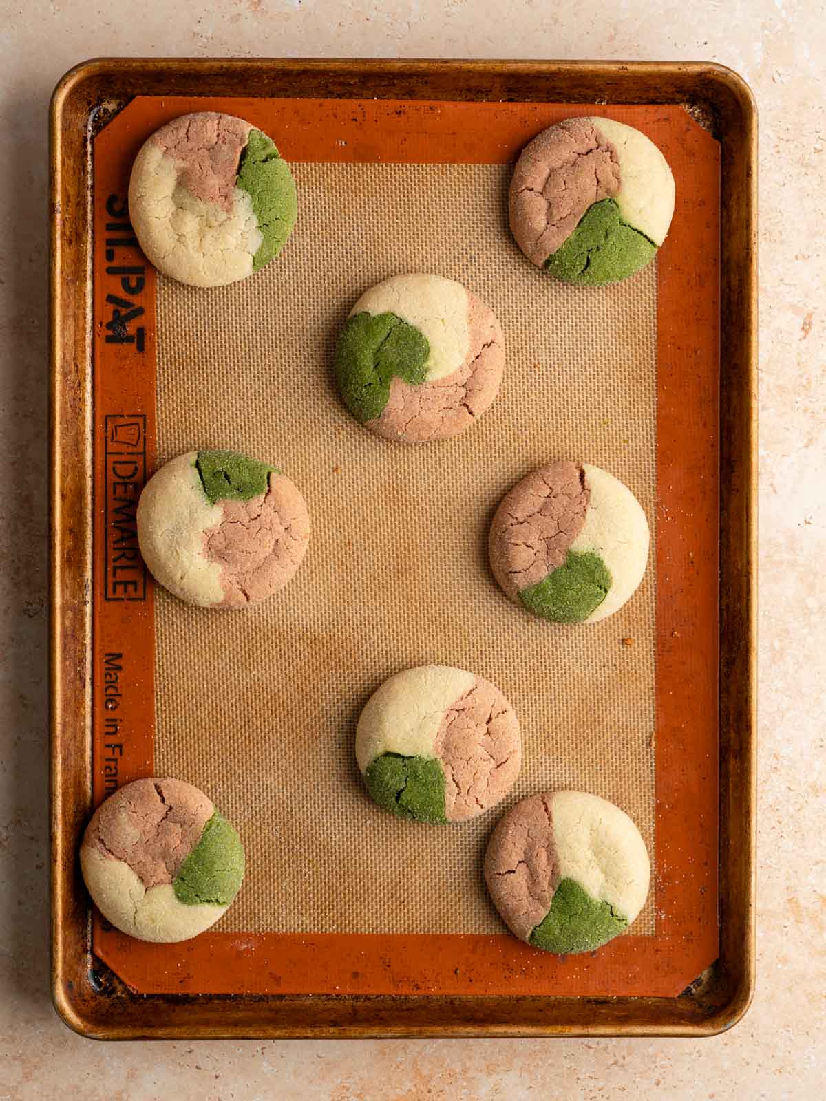 Baked vegan matcha neapolitan cookies on a rimmed baking sheet.